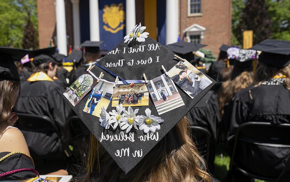 A graduate's cap adorned with images of friends reading all that I am I owe to those who believed in me.
